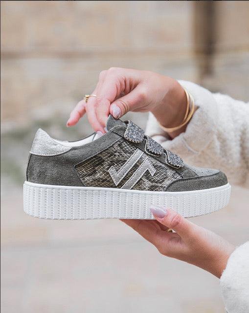 Modèle phare de la collection.

C’est une basket python, qui dispose d’empiècements kaki, que l’on retrouve également sur un bon ensemble de la chaussure.

Un contrefort arrière et des scratchs de fermeture dentelés&nbsp;à paillettes kaki.
