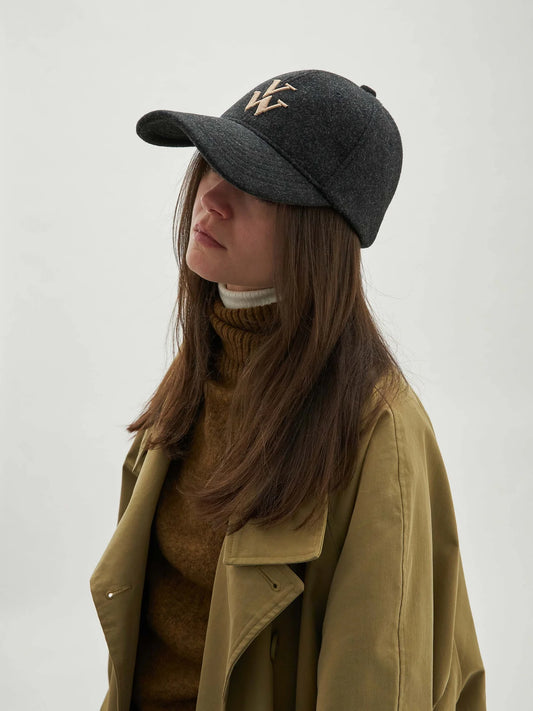 - Casquette noir et gris anthracite en feutre
- Visière avec surpiqûres décoratives
- Monogramme brodé beige
- Couronne en 6 pans avec œillets brodés
- 2 pans avant rigides
- Bande de propreté intérieure
- Fermeture arrière réglable à scratch