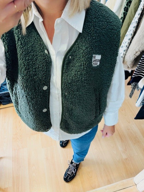 Gilet sans manches effet bouclette.

Coloris: Kaki

Patch sur l'avant " BE AWESOME TODAY"

Deux poches.

Fermeture boutons pressions.