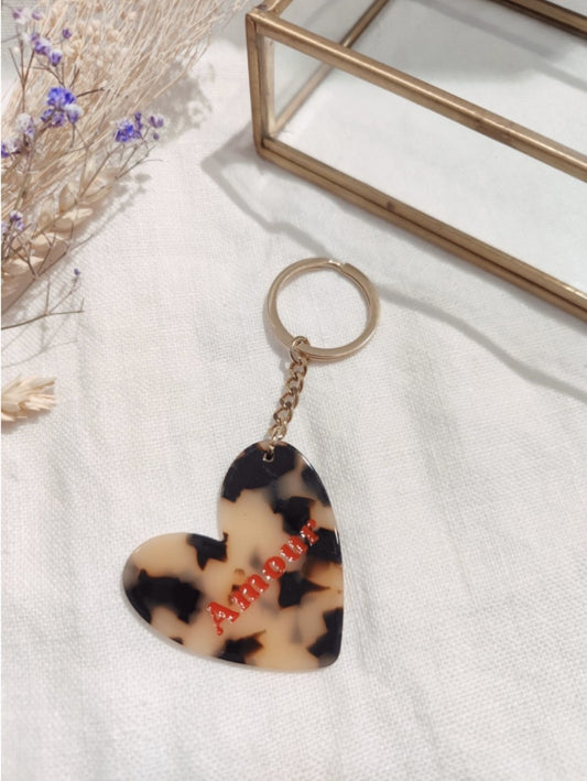 Porte clés "Amour""

- Forme cœur

- Couleur: imprimé léopard, inscription rouge

- Résine

Mile et Mila

Les accessoires ne sont ni repris, ni échangés
