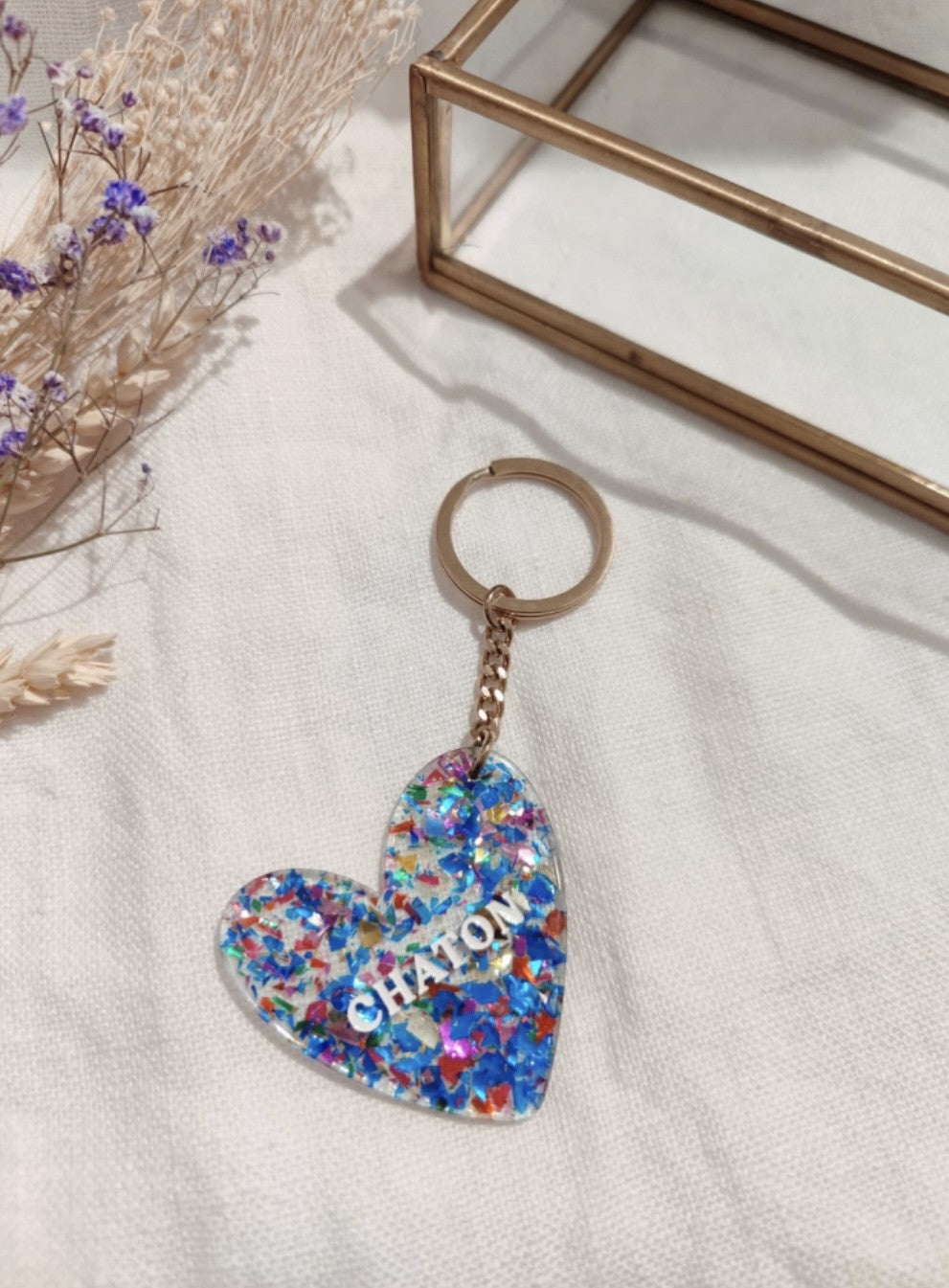 Porte clés "Chaton"

- Forme cœur

- Couleur: pailleté, bleu

- Résine

Mile et Mila

Les accessoires ne sont ni repris, ni échangés