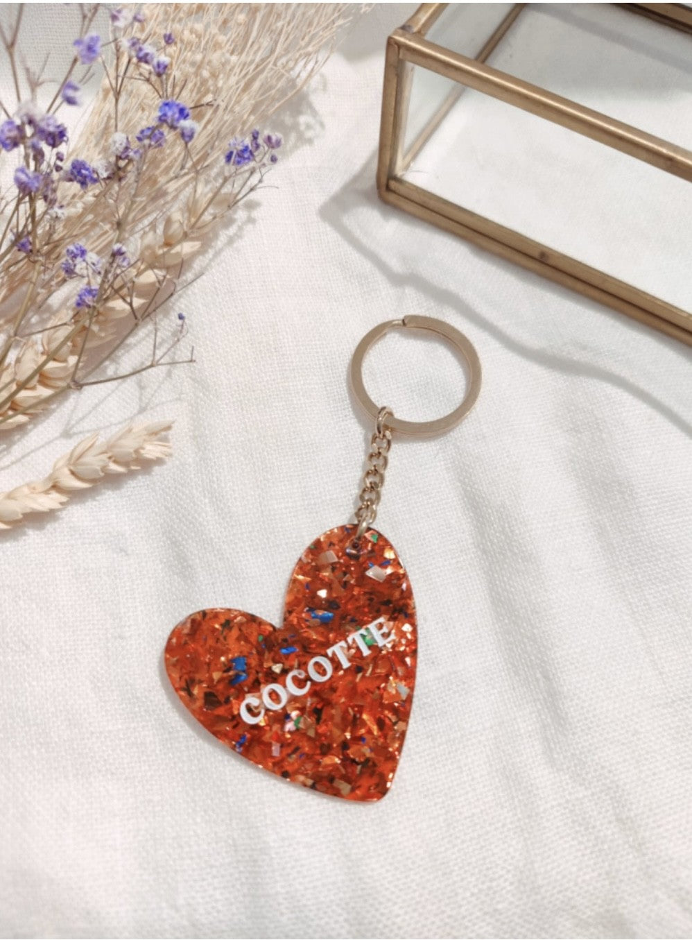 Porte clés "Cocotte"

- Forme cœur

- Couleur: pailleté, rouge

- Résine

Mile et Mila

Les accessoires ne sont ni repris, ni échangés