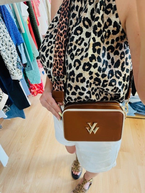 Sac trotteur en similicuir camel

Monogramme or

Liserés débordants en similicuir blanc

Fermeture éclair dorée

Compartiment intérieur avec une poche plaquée ouverte et une poche plaquée à fermeture éclair

Bandoulière large amovible et réglable, en tissu à imprimé léopard

Boucles et mousquetons dorés



Marque: Vanessa Wu